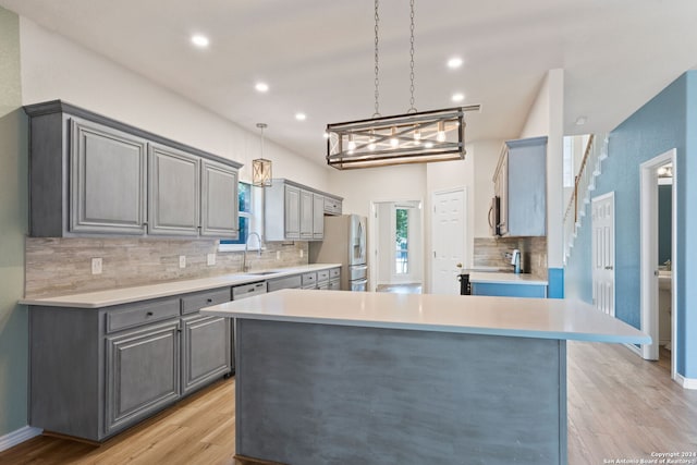 kitchen featuring light wood-type flooring, gray cabinets, and stainless steel appliances