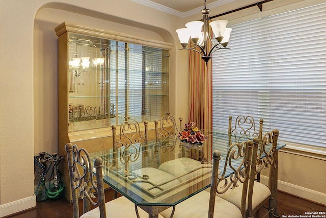 dining room featuring dark hardwood / wood-style floors, ornamental molding, and an inviting chandelier