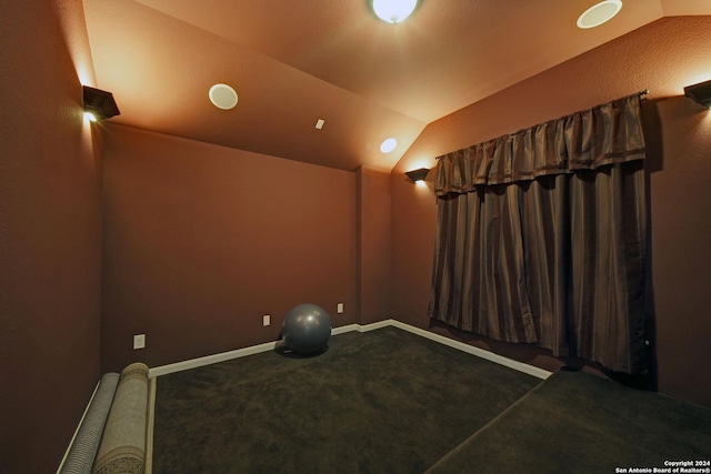 cinema room featuring carpet and vaulted ceiling