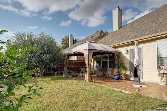 back of property with a gazebo, a yard, and a patio