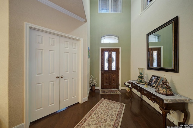 entrance foyer with dark hardwood / wood-style floors and crown molding