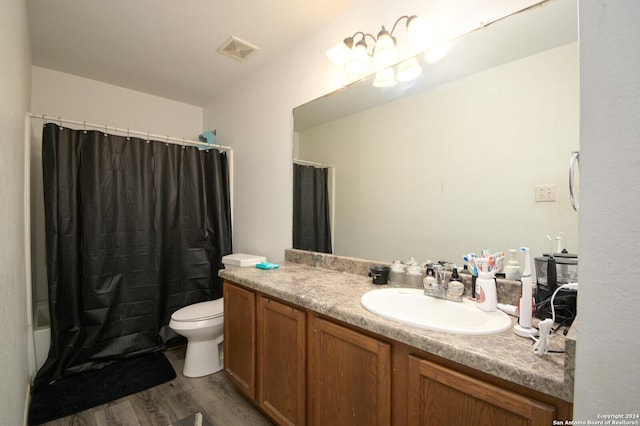 full bathroom with hardwood / wood-style floors, vanity, toilet, and shower / bathtub combination with curtain