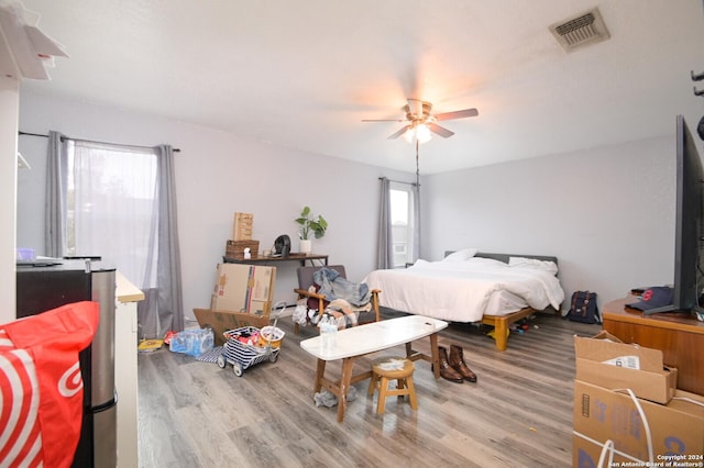 bedroom featuring multiple windows, ceiling fan, and hardwood / wood-style flooring