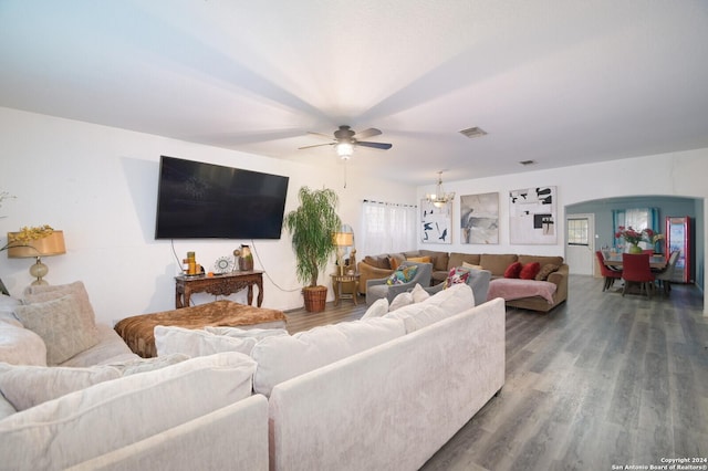 living room with ceiling fan with notable chandelier and hardwood / wood-style flooring