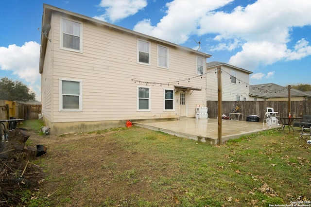 rear view of house featuring a lawn and a patio