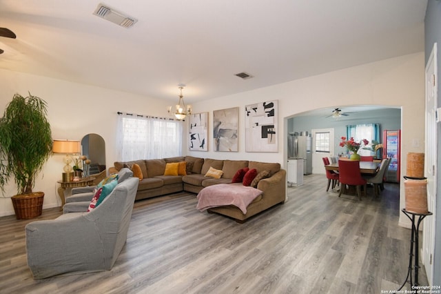 living room featuring wood-type flooring and ceiling fan with notable chandelier