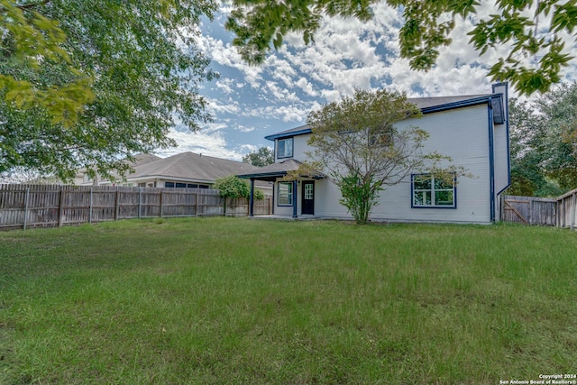 back of house featuring a yard