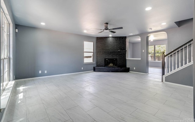 unfurnished living room featuring a fireplace and ceiling fan