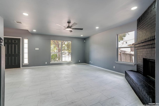 unfurnished living room with ceiling fan and a fireplace