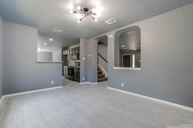 unfurnished living room featuring an inviting chandelier