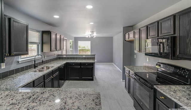 kitchen with black appliances, sink, dark brown cabinets, light stone counters, and kitchen peninsula