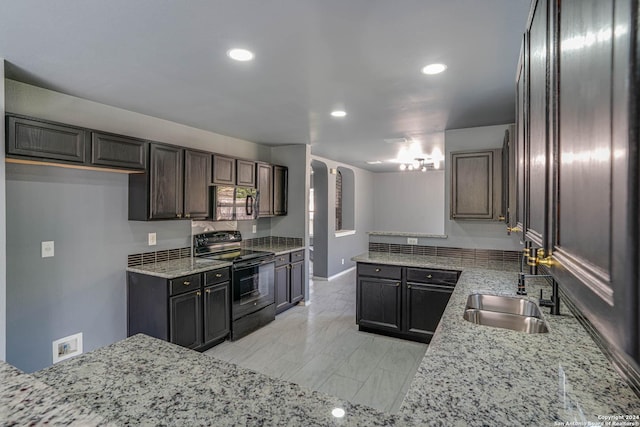 kitchen featuring electric range, sink, light stone counters, and dark brown cabinets