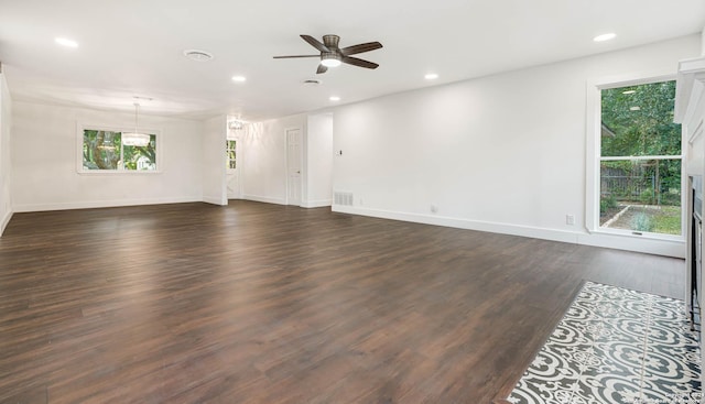 empty room featuring a wealth of natural light, dark hardwood / wood-style flooring, and ceiling fan