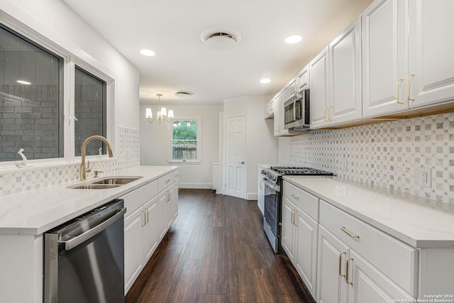 kitchen with appliances with stainless steel finishes, dark hardwood / wood-style flooring, sink, white cabinetry, and hanging light fixtures