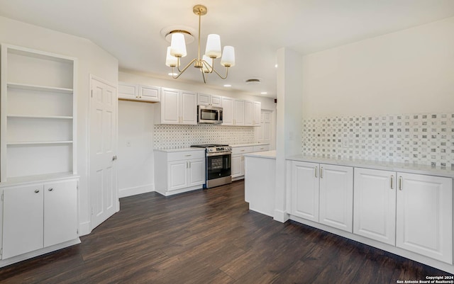 kitchen with white cabinets, appliances with stainless steel finishes, dark hardwood / wood-style flooring, and hanging light fixtures