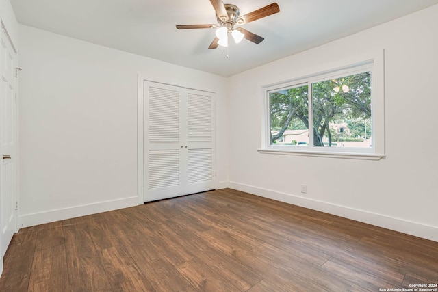 unfurnished bedroom with a closet, dark hardwood / wood-style floors, and ceiling fan