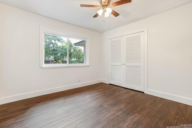 unfurnished bedroom with a closet, dark hardwood / wood-style floors, and ceiling fan