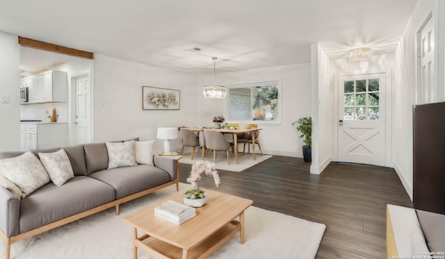 living room with dark wood-type flooring and an inviting chandelier