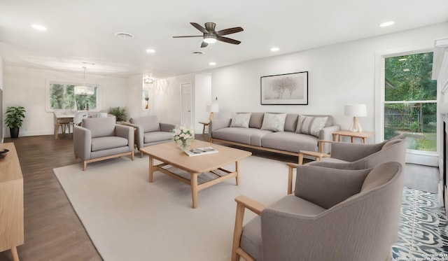 living room featuring ceiling fan and dark wood-type flooring