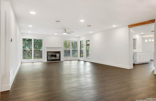 unfurnished living room featuring ceiling fan, plenty of natural light, and dark hardwood / wood-style floors