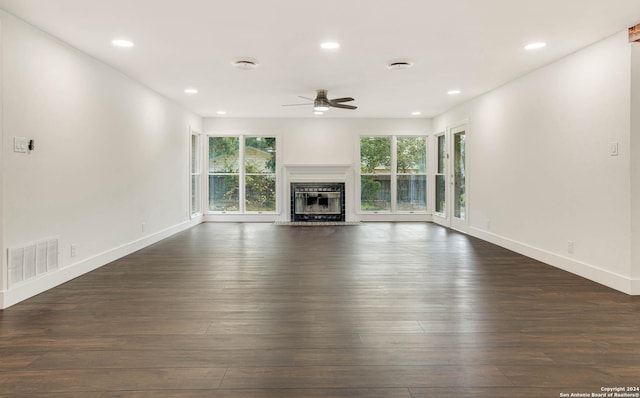 unfurnished living room featuring dark hardwood / wood-style floors and ceiling fan