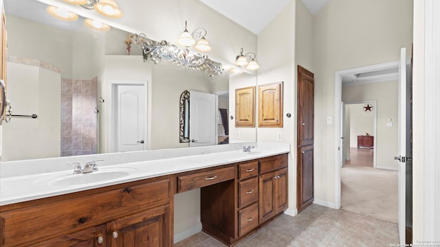 bathroom with tile patterned flooring, vanity, lofted ceiling, and an inviting chandelier