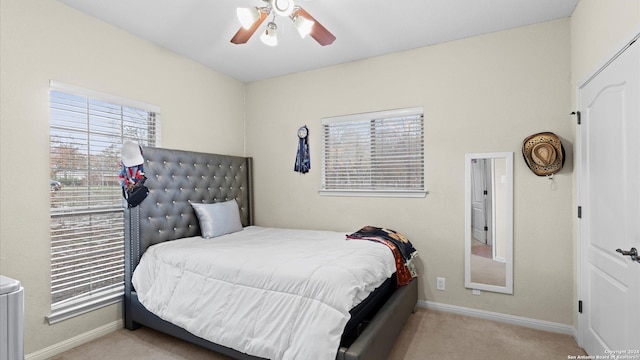 carpeted bedroom with multiple windows and ceiling fan