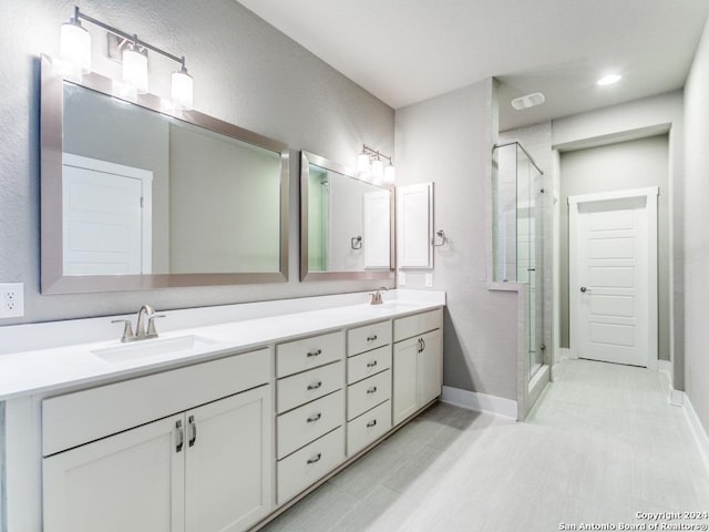 bathroom with a shower with door and vanity