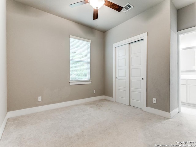 unfurnished bedroom with ceiling fan, a closet, and light carpet