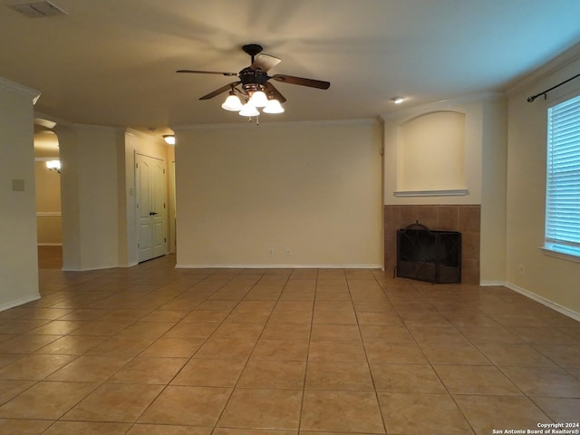 unfurnished living room featuring a tile fireplace, ceiling fan, crown molding, and light tile patterned flooring