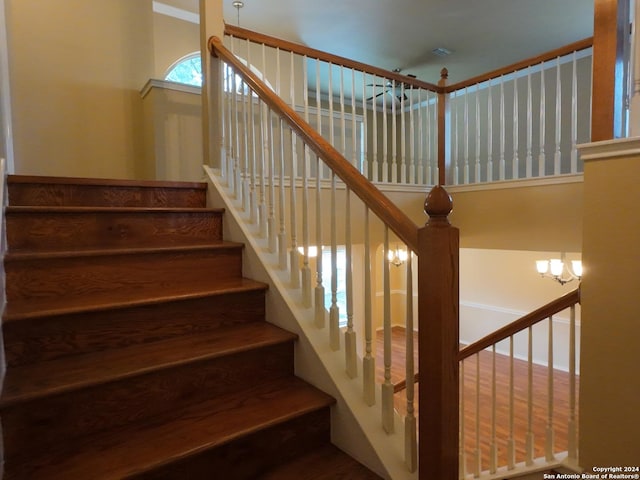 stairs featuring a chandelier