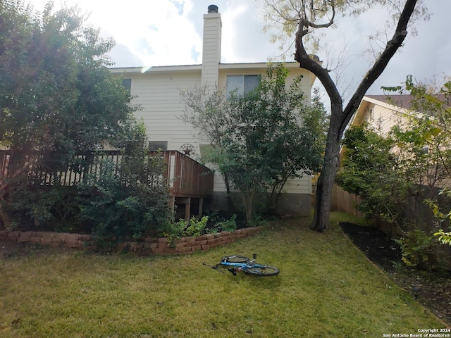 rear view of house with a yard and a wooden deck