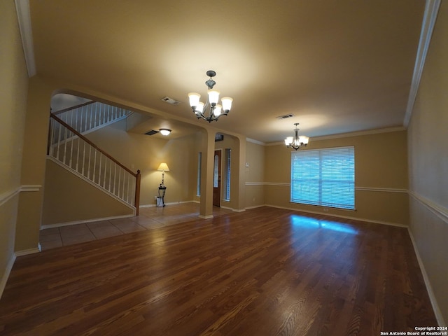 unfurnished living room featuring a chandelier, hardwood / wood-style flooring, and crown molding