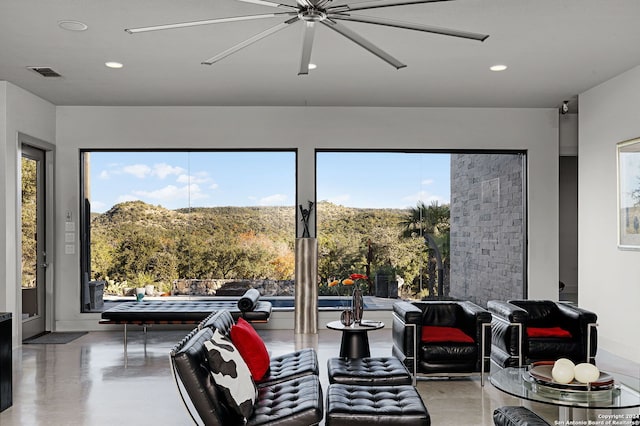 interior space featuring ceiling fan and concrete flooring