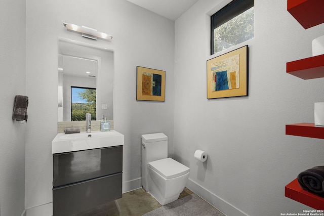 bathroom featuring plenty of natural light, toilet, and vanity