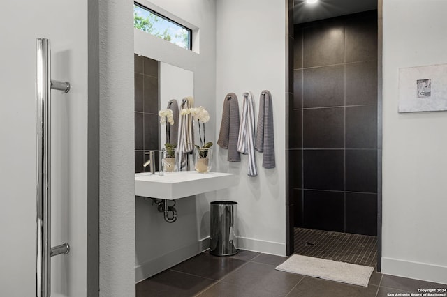 bathroom with tile patterned floors, sink, and tiled shower