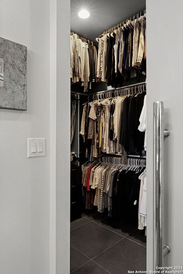 spacious closet with dark tile patterned floors