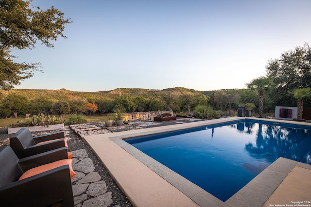 view of pool with a mountain view and a patio area