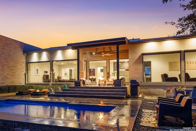 back house at dusk featuring a patio and ceiling fan