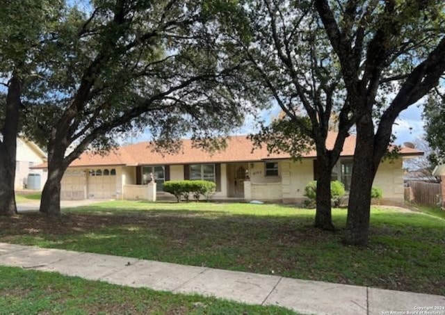 ranch-style home with a garage and a front lawn