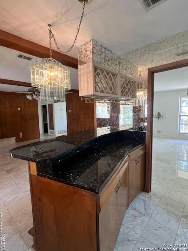 kitchen with a notable chandelier, decorative light fixtures, and dark stone counters