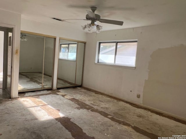 unfurnished bedroom featuring multiple closets and ceiling fan