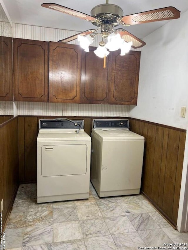 laundry room featuring independent washer and dryer, cabinets, ceiling fan, and wood walls