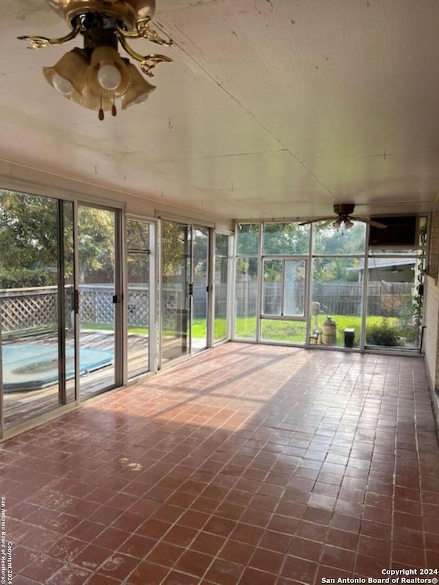 unfurnished sunroom featuring ceiling fan