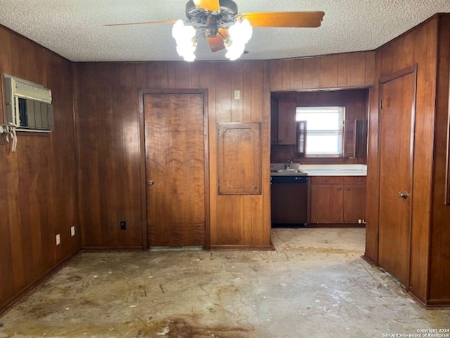 interior space with ceiling fan, a textured ceiling, and wood walls