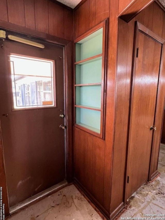 doorway to outside featuring wooden walls