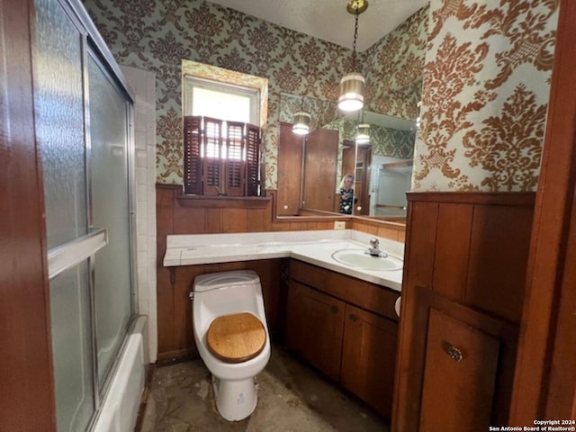 full bathroom with vanity, bath / shower combo with glass door, and toilet