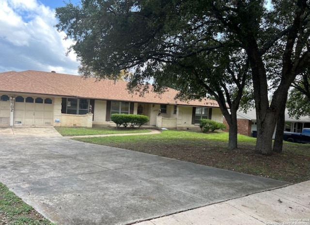 ranch-style house featuring a garage and a front yard