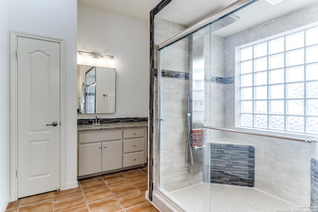 bathroom featuring tile patterned flooring, vanity, and an enclosed shower