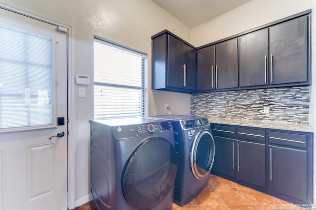 clothes washing area featuring cabinets, separate washer and dryer, and light tile patterned floors